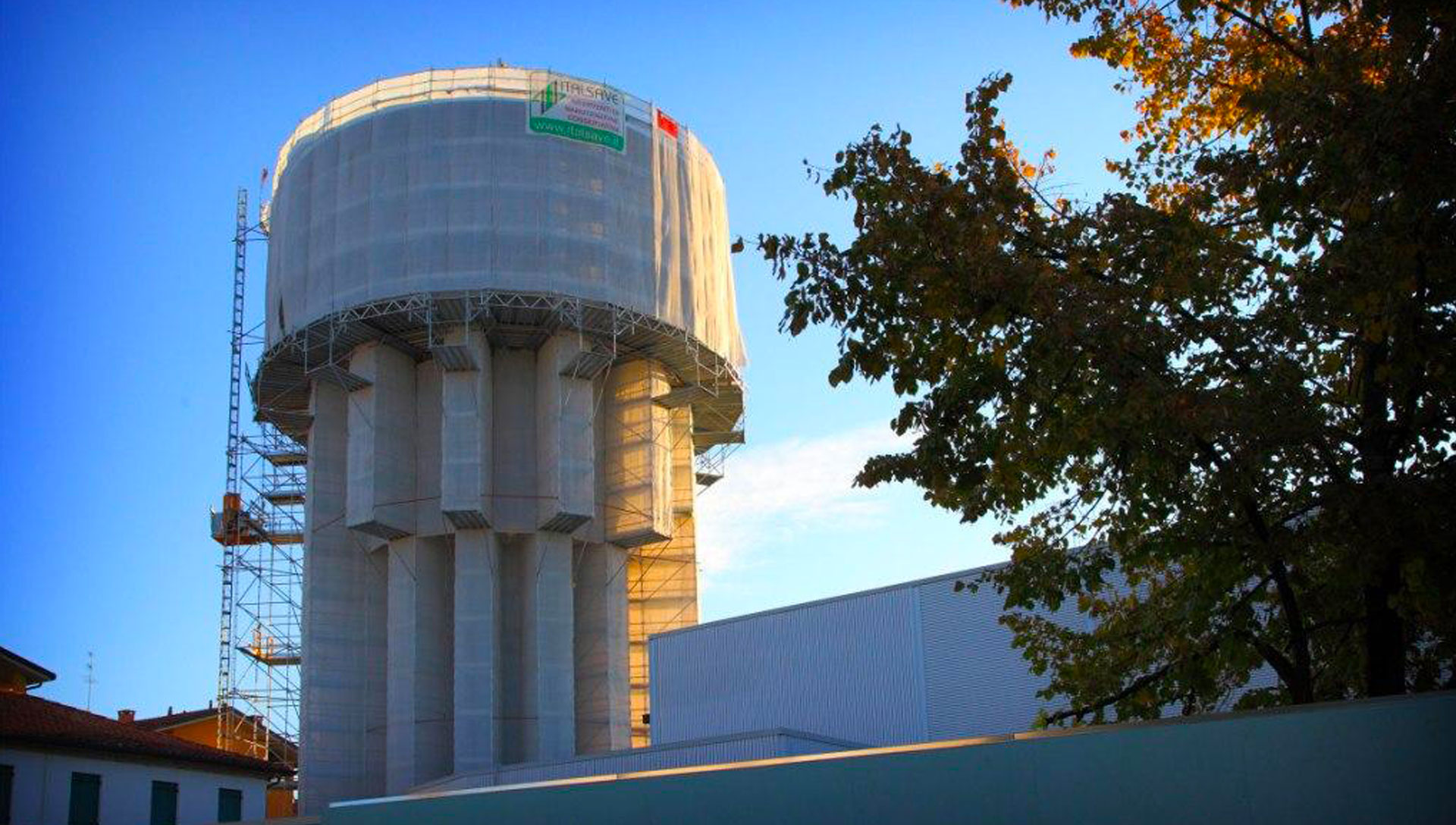 Torre pensile allestita con ponteggio, teli protettivi e montacarichi